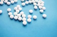 Weiße runde Pillen auf blauem Hintergrund