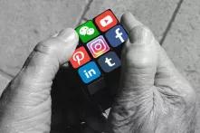 Hände halten Würfel mit Logos verschiedener sozialer Medien