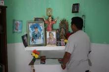Cristian Sulub in front of an altar with photos