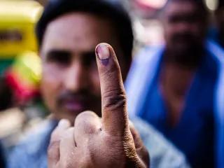 A voter displays his inked finger for a photograph after casting his vote at a polling station during the third phase of voting for national elections in New Delhi, India, on Thursday, April 10, 2014.