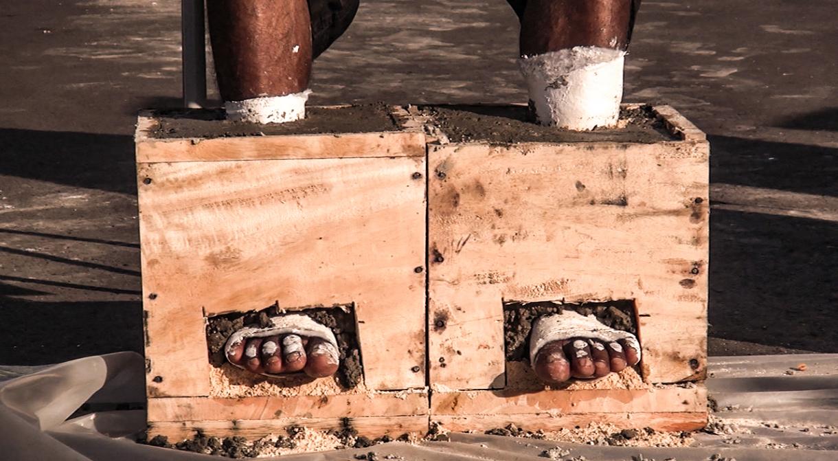 Vertreter/innen der indigenen Samin zementieren ihre Füße ein, um gegen die Zerstörung des Karstgebirges in Central-Java zu protestieren Einzementierte Füße Zement