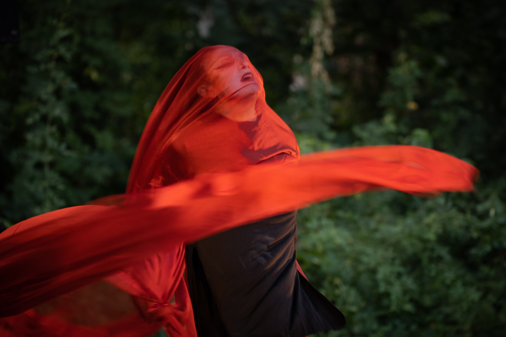 Hanane Hajj Ali während ihrer Performance "Jogging". Sie wirbelt ein transparentes rotes Tuch um sich herum und über ihr Gesicht.