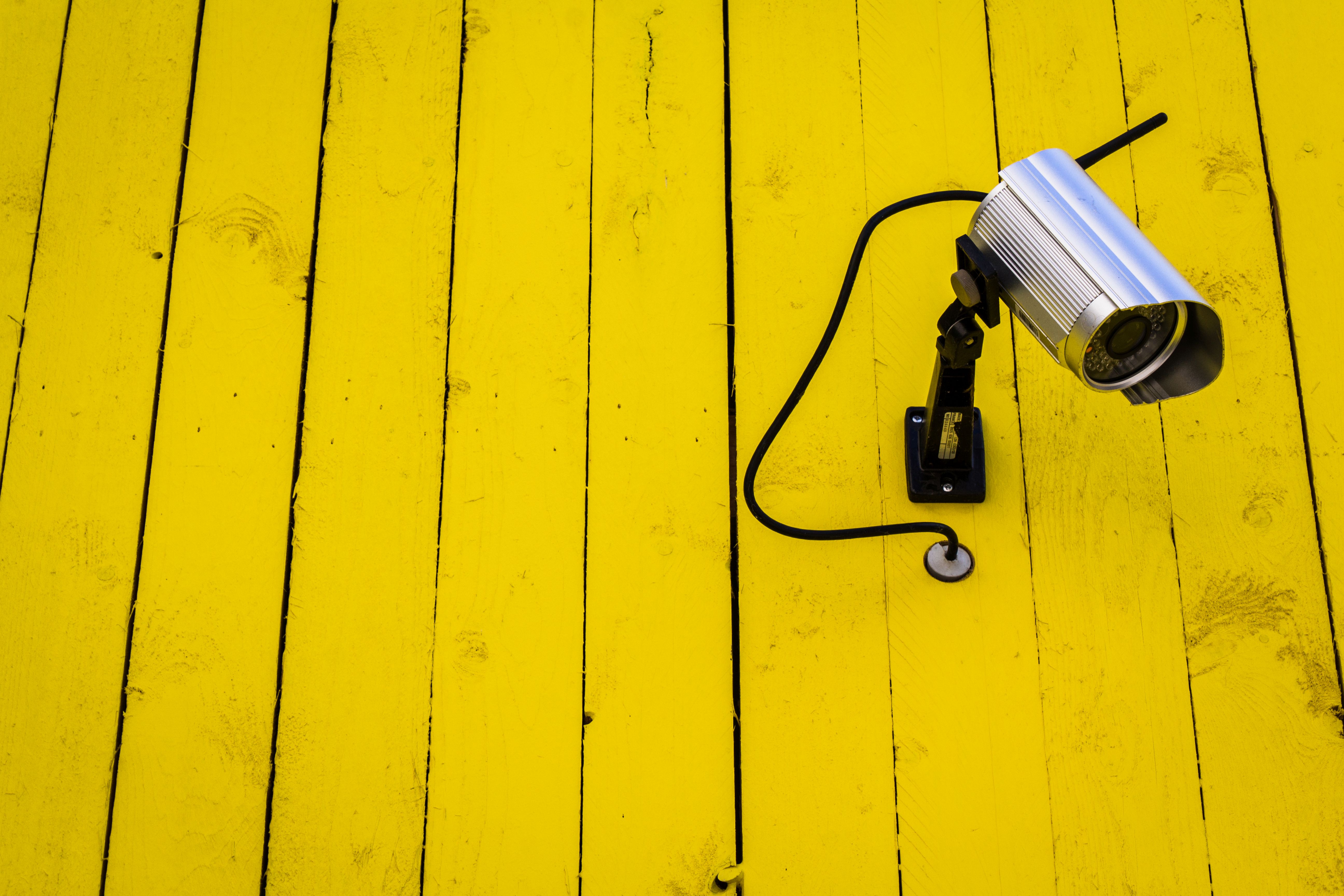 Yellow Watcher Yellow Watcher - Kamera an gelber Bretterwand