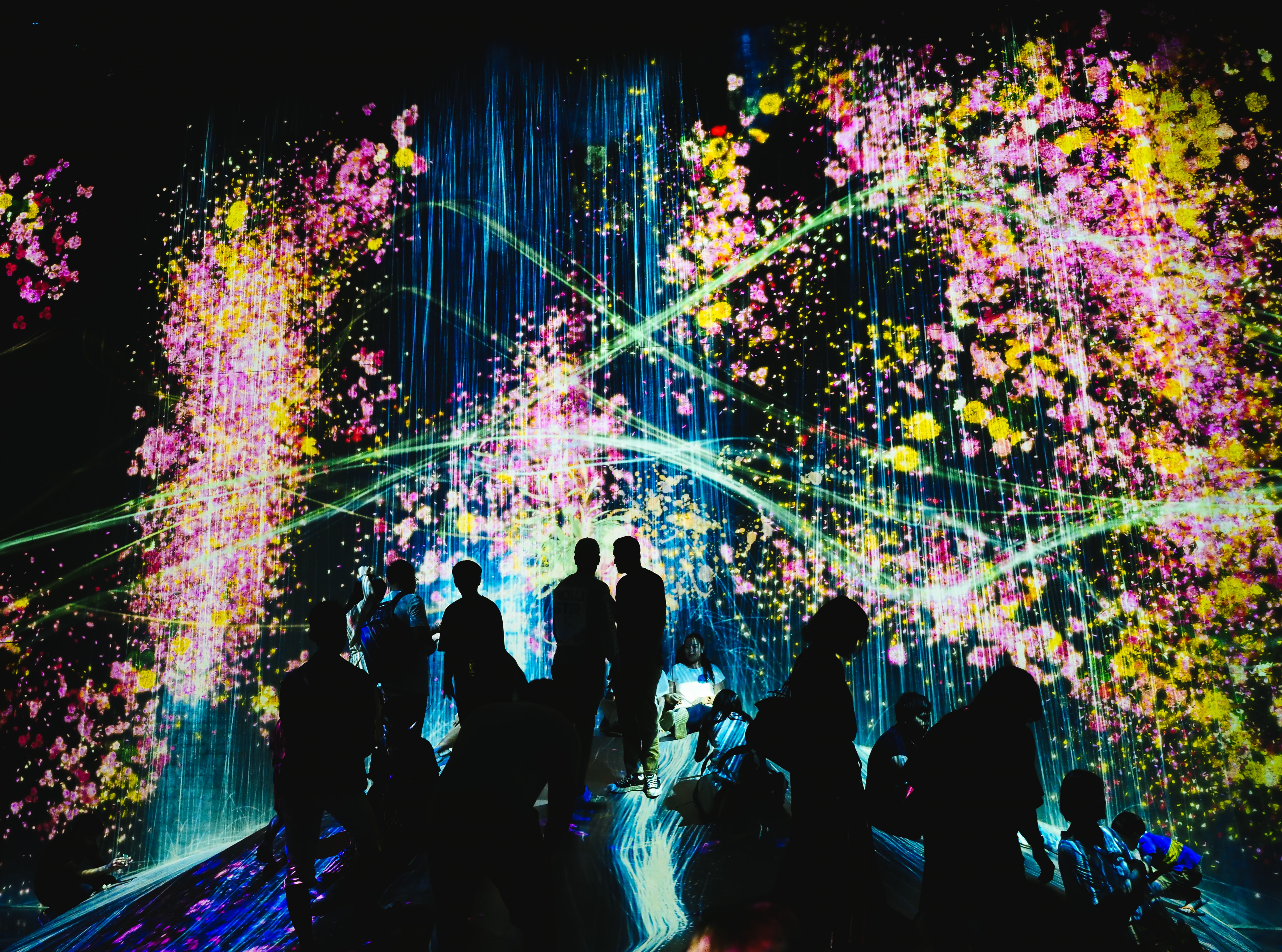 Shot in the teamLab Borderless light museum during a projection of a waterfall and neon colors in Tokyo, Japan. Aufgenommen im teamLab Borderless Light Museum während einer Projektion eines Wasserfalls und Neonfarben in Tokio, Japan.