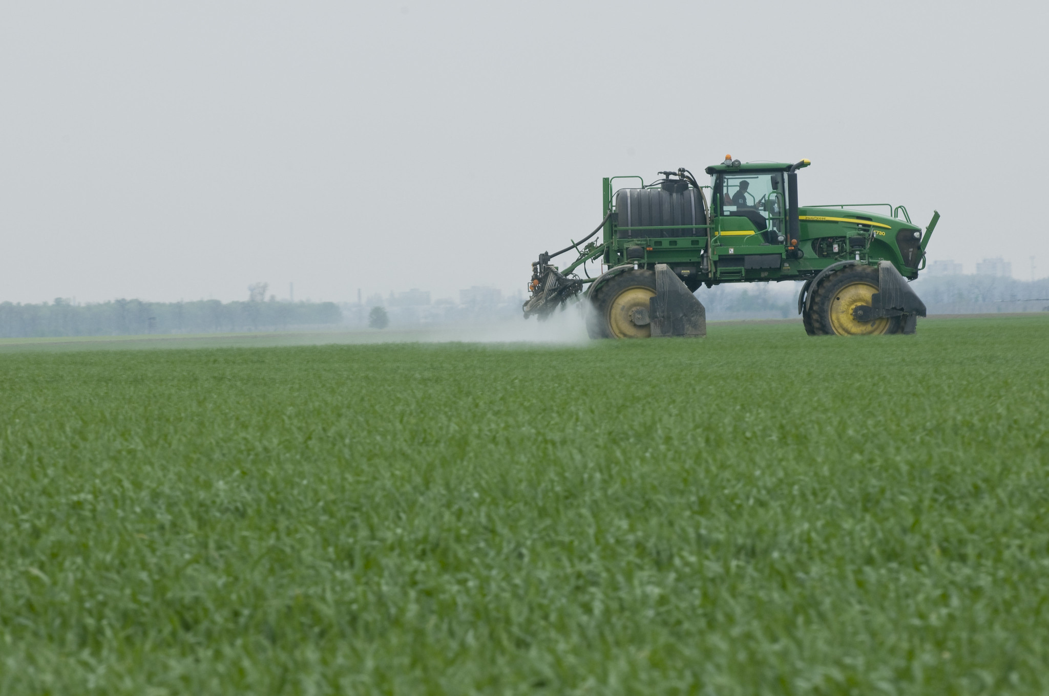 Ein Traktor düngt ein Feld Ein Traktor düngt ein Feld