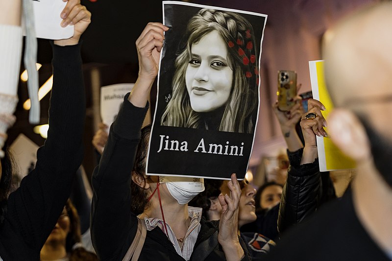 Demonstrantin mit Bild von JIna Amini Eine Demonstrantin hält ein Bild von Jina Amini hoch
