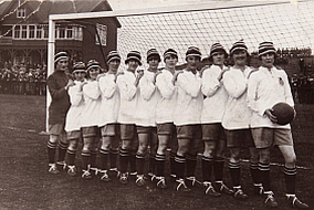 Elf Spielerinnen aufgereiht vor einem Fussballtor, 1921