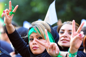 Zwei iranische Frauen mit Victory-Zeichen und grünen Schleifen