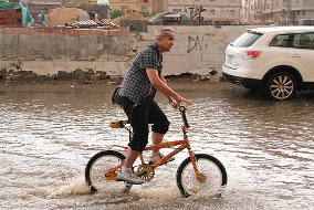 Man riding a bike in the city of Jedda during a flood in 2011