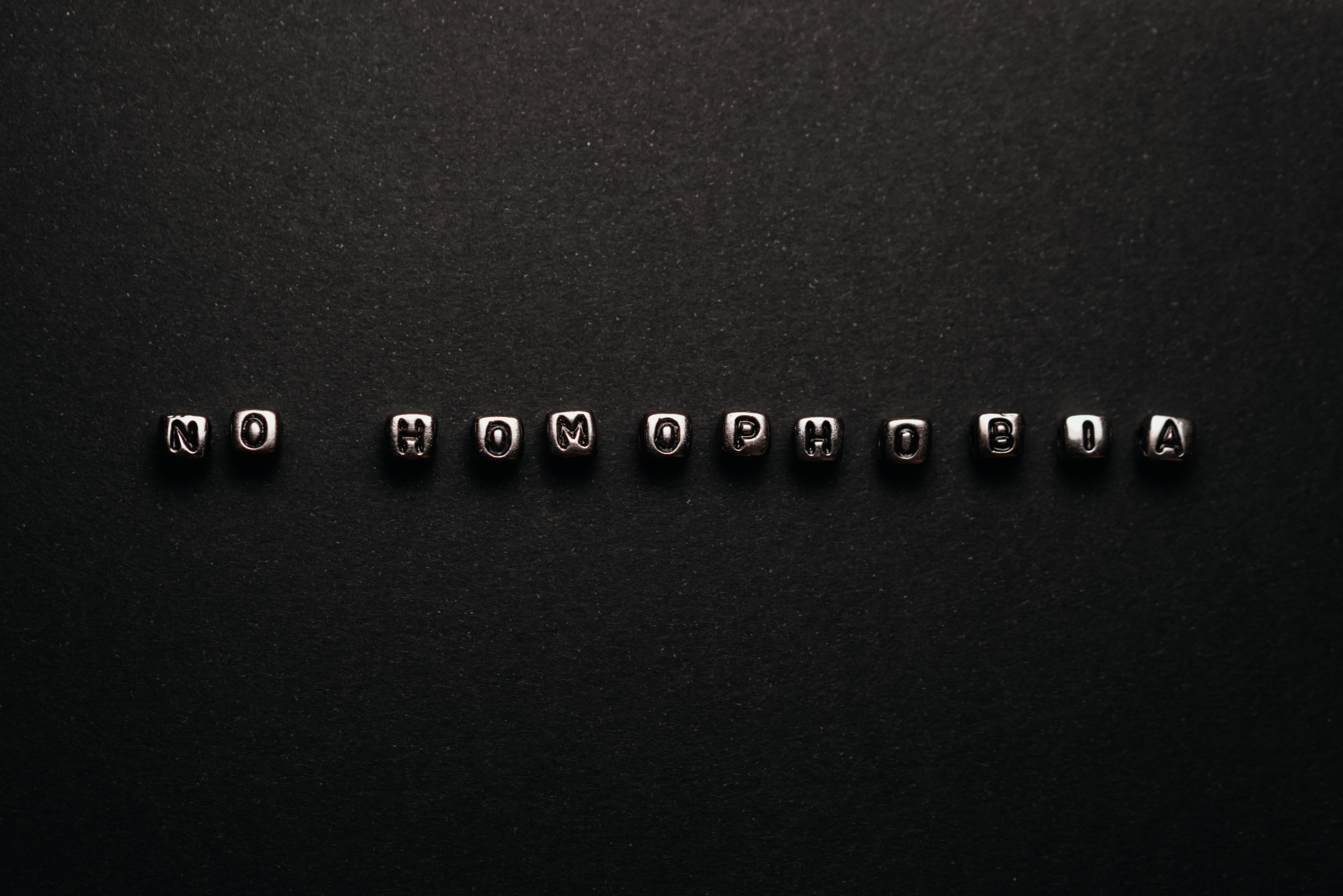 "No Homophobia" written in metal perls on black surface