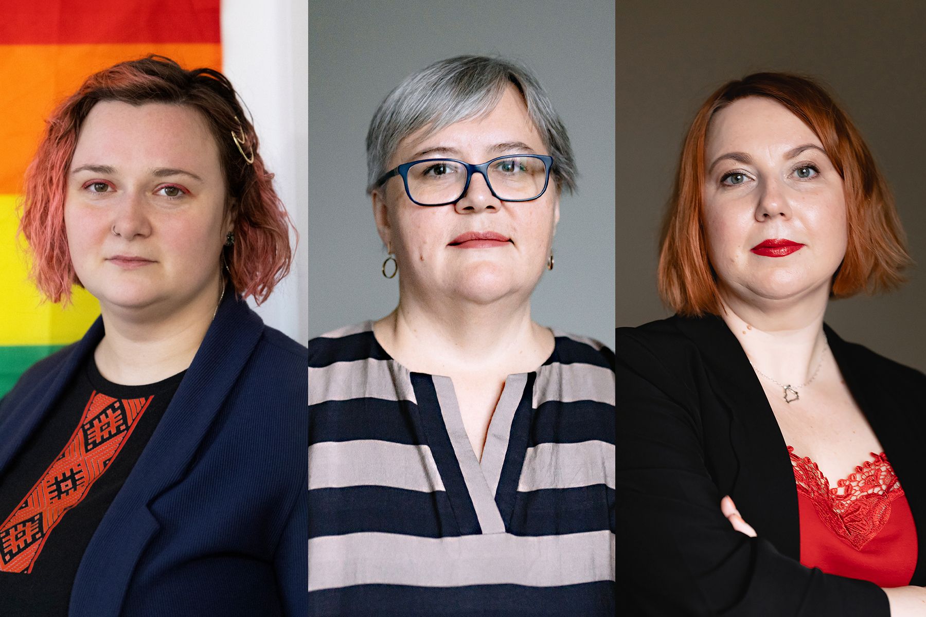 Foto: Drei Personen nebeneinander. Links vor Regenbogenflagge, mittig mit grauem Haar, rechts mit rotem Lippenstift, Arme verschränkt.