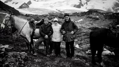 Ein schwarz-weißes Bild Yvon Chouinard, Chris Tompkins und Doug Tompkins zusammen in den Bergen. Es gibt zwei Pferde neben der Kleingruppe