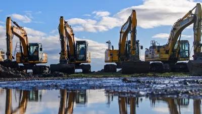 Vier Bagger stehen in Magdeburg nebeneinander