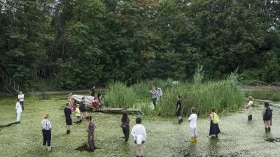Mehrere Menschen stehen beim Floating University im Wasser