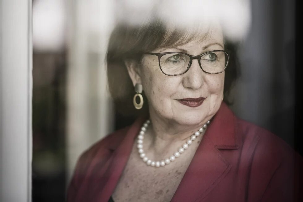 Portrait Prof. Dr. Seyla Benhabib, Yale Portrait Prof. Dr. Seyla Benhabib - mit Brille blickt nach rechts aus einem Fenster, Spiegelungen verdecken Teile des Gesichts.