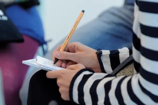 Mensch mit Stift macht Notizen