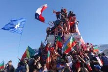 Das Bild zeigt protestierende Menschen mit Fahnen in Chile