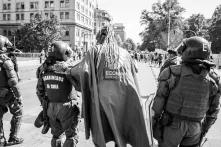Das Bild zeigt Polizisten und einen Demonstrant