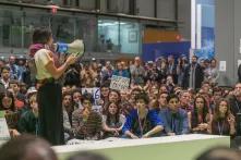 A girl speaking at COP25 in front of many young people 