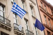 Erwartungen der griechischen Regierung: Griechische und europäische Flaggen an einem Gebäude angebracht.