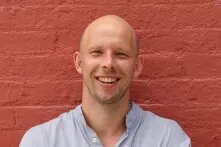 Portrait Philipp Kühl vor roter Mauer