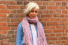Dr. Elif Çiğdem Artan steht für ein Foto vor einer Mauer