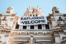 Ein Banner mit der Aufschrift "Refugees welcome" hängt am Rathaus von Madrid.