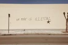 Eine Wand ist mit dem Satz "No one is illegal" beschriftet