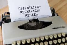 Ein Blatt Papier, auf dem "Öffentlich-Rechtliche Medien" steht, steckt in einer Schreibmaschine.