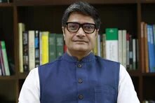 Chandra Bushan steht vor einem Bücherregal