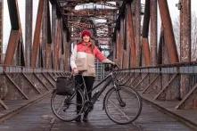 Madeleine Linke steht mit einem Fahrrad auf einer Brücke.