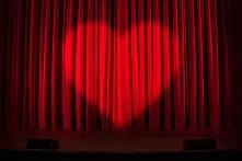 Roter Theatervorhang mit Spot in Form eines Herz