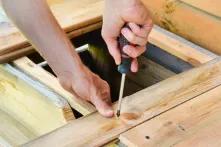 Handwerker dreht eine Schraube mit einem Schraubenzieher ein
