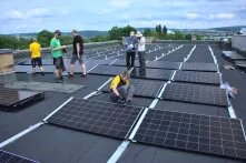 Menschen auf einem Dach bei Aufbau einer Solaranlage