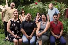 Team-Foto im Garten: Sechs Personen sitzen, zwei Personen stehen