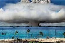 Explosion of an atomic bomb with a mushroom cloud, in the foreground beach with palm trees