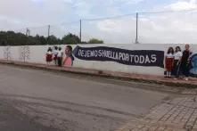 Gladys Pinto with student girls in front of "dejemos huella por todas"