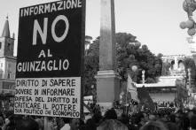 A Demonstration for freedom of press in Rome, Italy. In the foreground a sign saying "Right to Knowledge, Duty to Inform, Defense of the Right to Criticize Both Political and Economic Power"