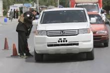 An Afghan security force member checks a vehicle in Kabul