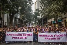 Demonstrierende die 2 Banner hochhalten, auf denen steht: "Anderson Gomes Presente" und "Marielle Franco Presente"