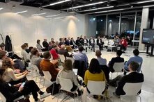 mehrere Personen sitzen in einem großen Raum der Heinrich Böll Stiftung in einem Halbkreis mit Stühlen