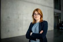 Portrait Marlene Schönberger, Frau mit schulterlangen rötlichen Haaren und Brille