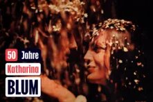 Nahaufnahme von zwei sich anblickenden Personen. Links Text: „50 Jahre Katharina Blum.“