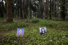 Zwei Fotos stehen im Wald auf dem Boden, dabei handelt es sich um Montha Chukaew und Pranee Boonrat, Mitglieder der Southern Peasants’ Federation of Thailand, die im Jahr 2012 ermordet wurden. 