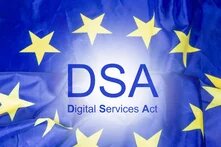 Illustration: Die EU-Flagge mit dem Text „DSA Digital Services Act“ in blauer Schrift auf einem hellen Lichtschein.