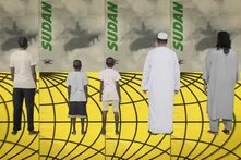 Illustration: A group of five people stands with their backs to the viewer in front of a yellow and black globe, with "SUDAN" written on a backdrop.