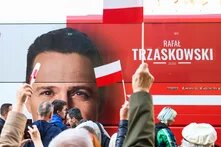 Menschen mit polnischen Fahnen vor einem Wahlkampfbus von Rafał Trzaskowski.