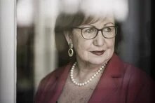 Portrait Prof. Dr. Seyla Benhabib - mit Brille blickt nach rechts aus einem Fenster, Spiegelungen verdecken Teile des Gesichts.