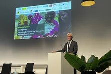 A man speaks at a podium in front of a screen reading: “Keynote Speech Jan Egeland, Norwegian Refugee Council (NRC)”.