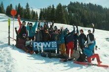 Eine Gruppe von Skifahrer*innen auf einem beschneiten Hügel.
